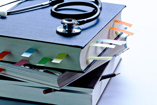 Stack of textbooks with stethoscope on top