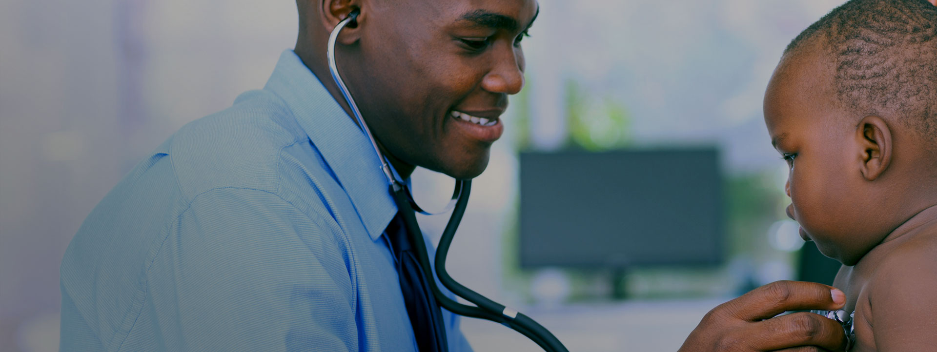 Young Black doctor checking a Black infant with a stethoscope.