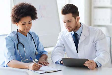Doctor writing on paper next to nurse